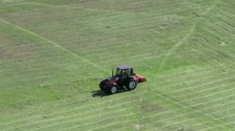 A mini tractor mows grass on a sunny summer day in a large clearing in the city Stock Footage 10572947