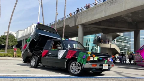 Mini Trucks with Hydraulic Dancing Beds ride through the Day of the Dead Parade 動画素材 255313413