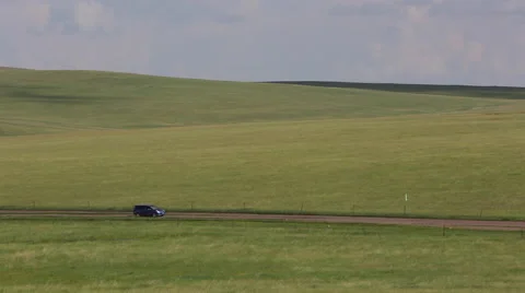 Mini van driving on an earth road through the grasslands Stock Footage 40490131