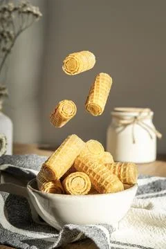 Mini waffle cookie rolls flying over a plate Stock Photos