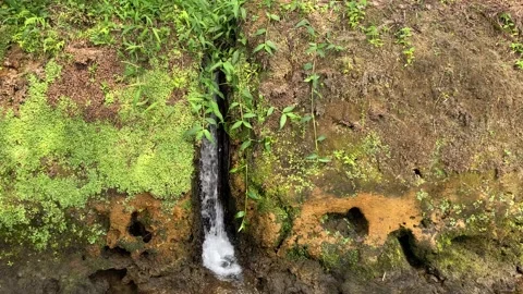 Mini waterfall from the water conduit to the river Stock Footage 295492315