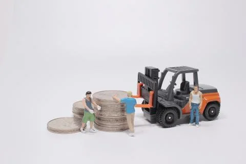 The mini worker use the forklift to move the coins Foto stock