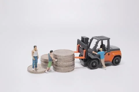 The mini worker use the forklift to move the coins Foto stock