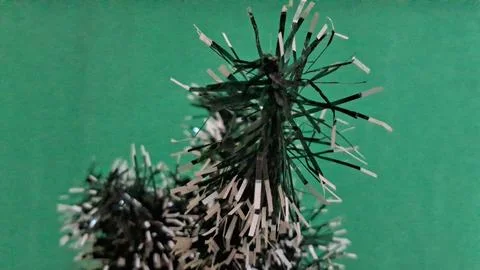 Miniature artificial pine tree with silver tips on green background Stock Photos