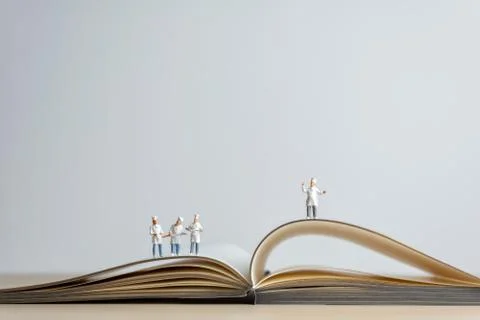 Miniature Chef standing on top of opened recipe book. Cooking concept Stock Photos