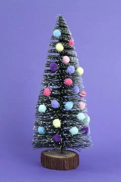 Miniature christmas tree decorated with mini garlands and pompoms as baubles Stock Photos