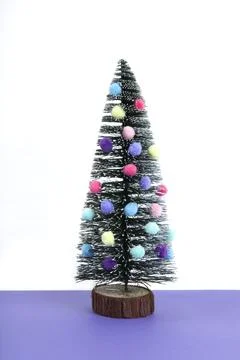 Miniature christmas tree decorated with mini garlands and pompoms as colorf.. Stock Photos