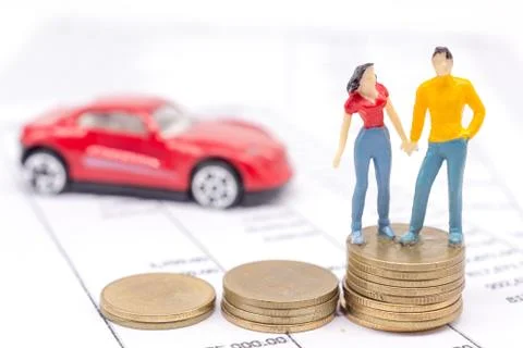 Miniature couple people and stack coins on statement and the car behind. savi Foto stock