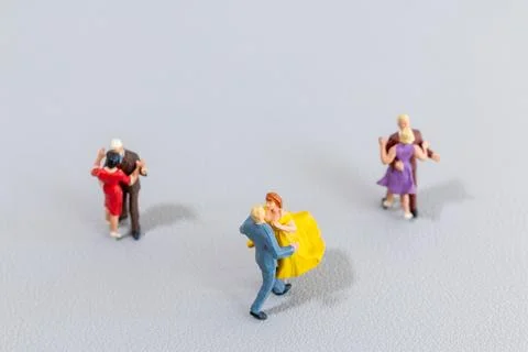 Miniature Couples Dancing on Light Background Stock Photos
