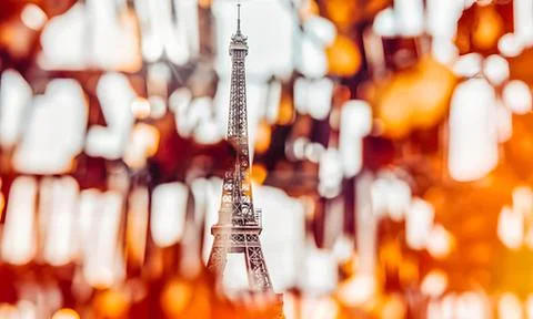 Miniature eiffel tower model with orange lights background Stock Photos