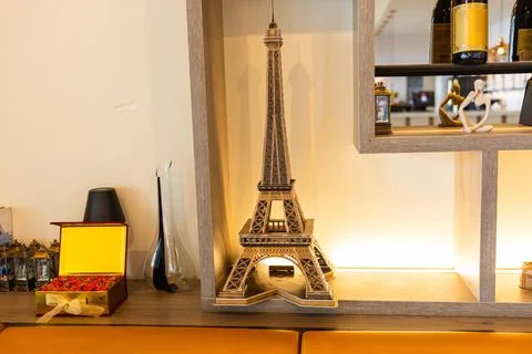 Miniature Eiffel Tower model placed on a wooden shelf. Parisian elegance, E.. Foto stock