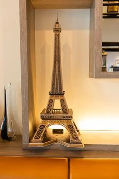Miniature Eiffel Tower model placed on a wooden shelf. Parisian elegance, E.. Foto stock