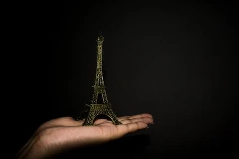 Miniature of Eiffel tower placed on a palm 스톡 사진
