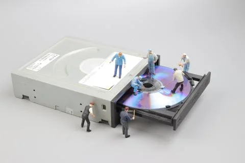 Miniature engineer and worker fixed to clean CD rom Stock Photos