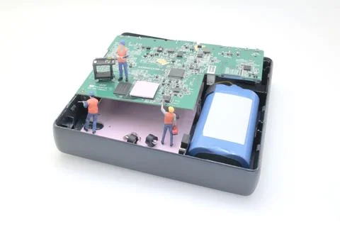 Miniature Engineers Working on Circuit Board Inside Opened Stock Photos