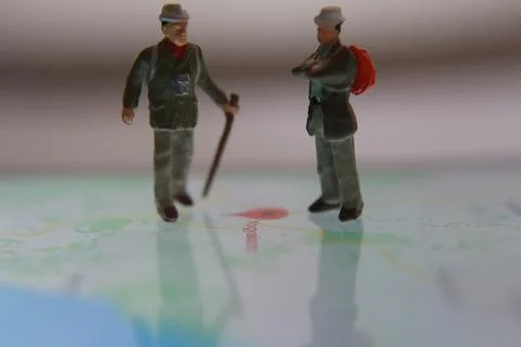 Miniature figure of an explorer posing on a digital map via a mobile phone Stock Photos