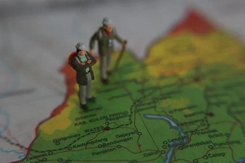 Miniature figure of an explorer posing on a map or atlas Stock Photos
