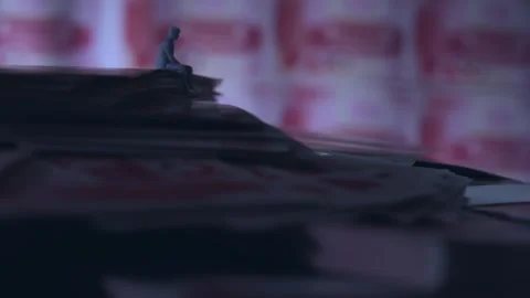 Miniature Figure Sitting Alone on Stack of Money, Close-up Stock-Footage 339067684