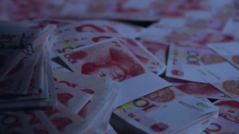 Miniature Figure Sitting on Stacks of Red Chinese Yuan Banknotes Vidéo 339067786