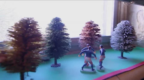 Miniature figures playing soccer in window sill. Tilt Stock Footage 40776403