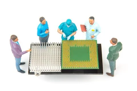 Miniature figures working around a computer chip model with a detailed setup Stock Photos