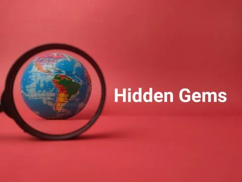 A miniature globe is focused inside a magnifying glass on a red background .. 库存照片