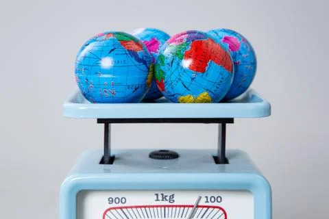 Miniature globe models on a scale Stock Photos