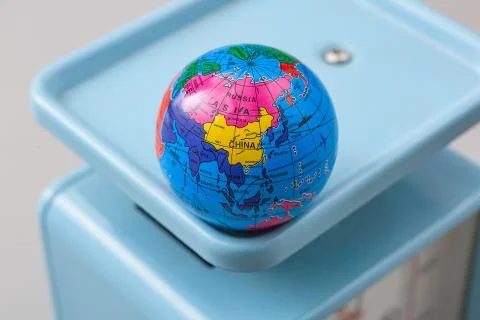 Miniature globe models on a scale Stock Photos