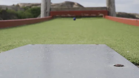 Miniature golf putter hitting golf ball and misses target, close up footage Stock Footage 159246937