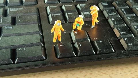 Miniature Hazmat Workers Cleaning Computer Keyboard Surface Stock Photos