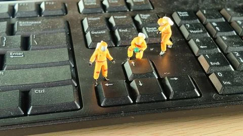 Miniature Hazmat Workers Cleaning Computer Keyboard Surface Stock Photos