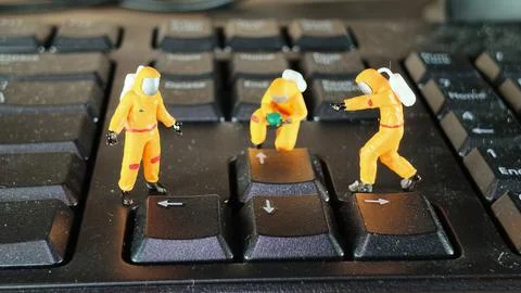 Miniature Hazmat Workers Cleaning Computer Keyboard Surface Stock Photos