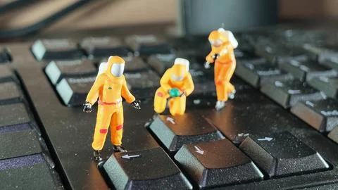 Miniature Hazmat Workers Cleaning Computer Keyboard Surface Stock Photos