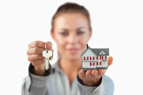 Miniature house and keys being presented by female estate agent Stock Photos