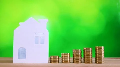 Miniature house and stack of golden money coin on wooden desk Stock Footage 281140215