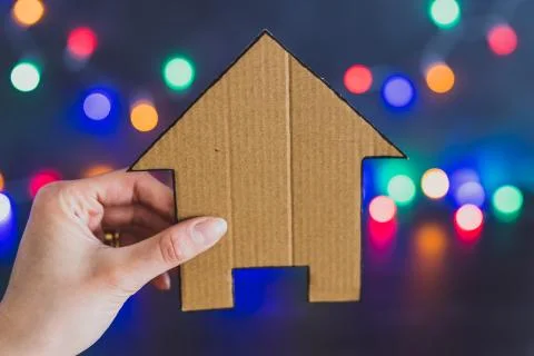 Miniature house with festive multicolour string lights bokeh Stock Photos