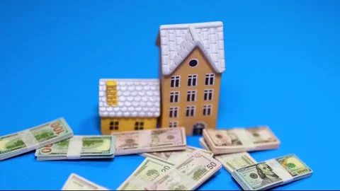 Miniature house model with pouring dollar banknotes, shows increase in real.. Vídeos de archivo 329659583