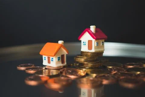 Miniature house on stack coins Stock Photos
