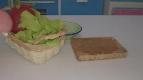 Miniature kitchen is bustling with activity as a tiny basket filled with lettuce Video stock 286886932
