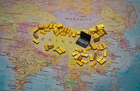 Miniature laptop with gold bars on China map tech wealth concept. Stock Photos