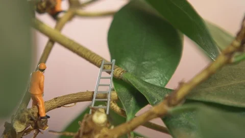 Miniature model men in orange overall in plant Stock-Footage 102555131