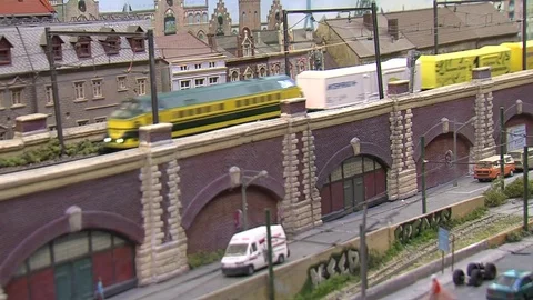 Miniature Model Scale Railway Train with wagons riding by in a urban setting Stock Footage 70513662