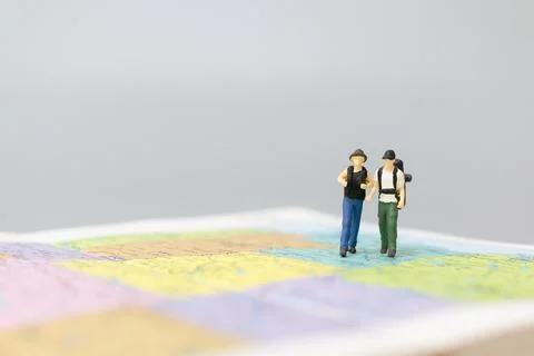 Miniature people Backpacker walking on map Stock Photos