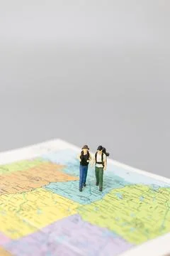 Miniature people Backpacker walking on map Stock Photos