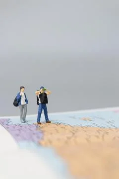 Miniature people Backpacker walking on map Stock Photos
