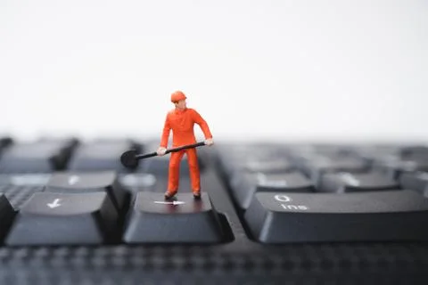 Miniature people, engineer standing on computer keyboard Foto stock