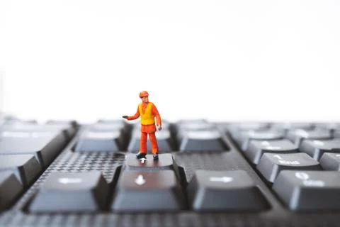 Miniature people, engineer standing on computer keyboard Stock Photos