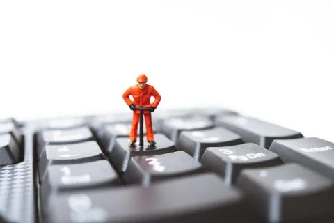 Miniature people, engineer standing on computer keyboard Stock Photos