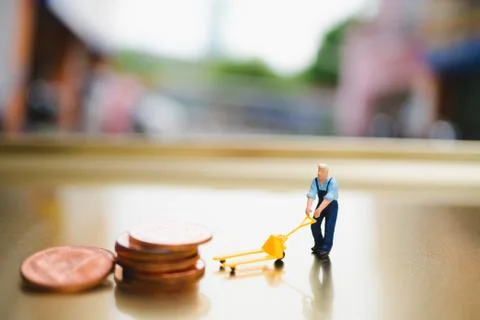 Miniature people, man moving stack coins Stock Photos
