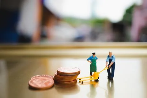 Miniature people, man moving stack coins Stock Photos